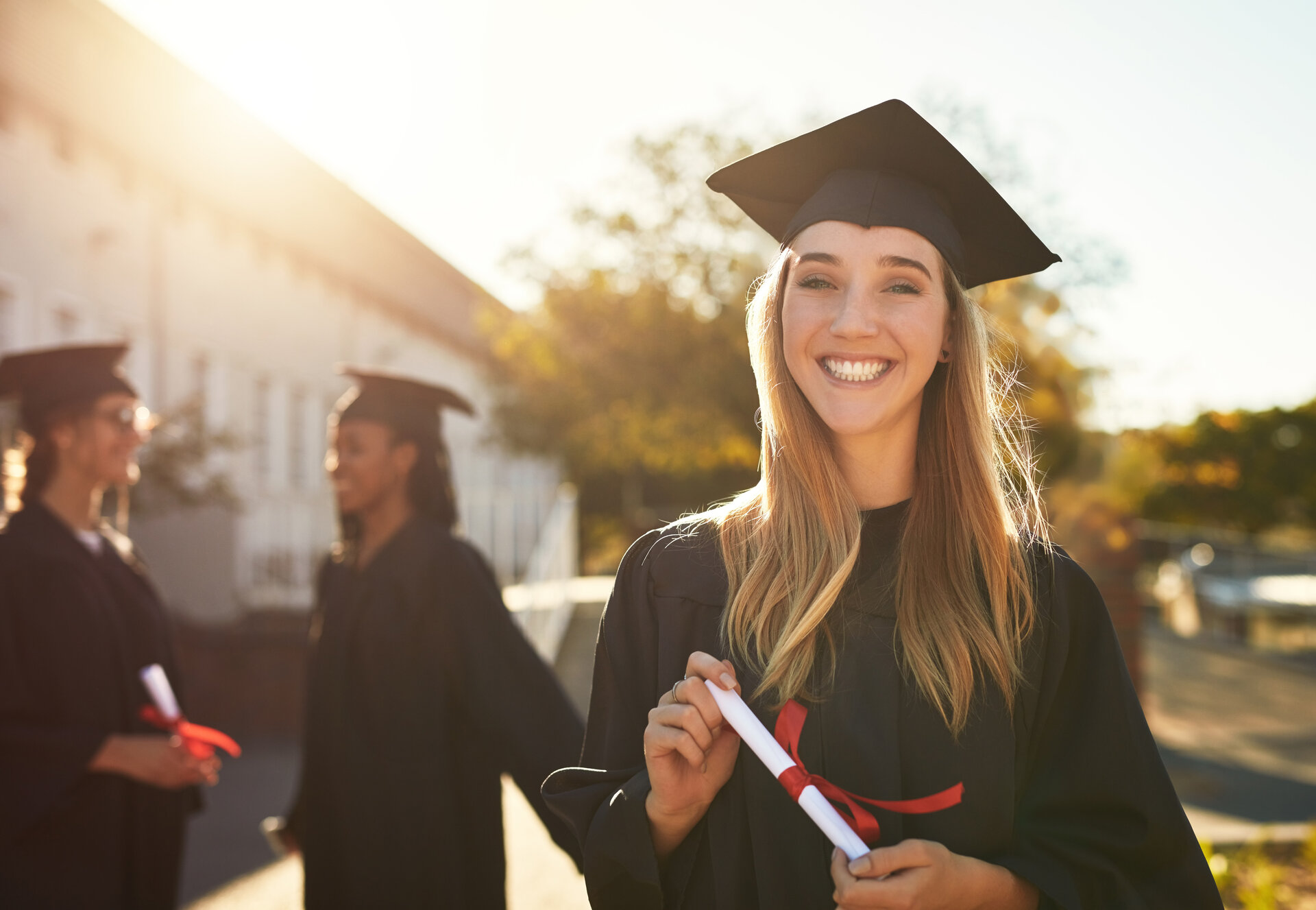 The dream is now a reality. Portrait of a happy young woman holding a diploma on graduation day.